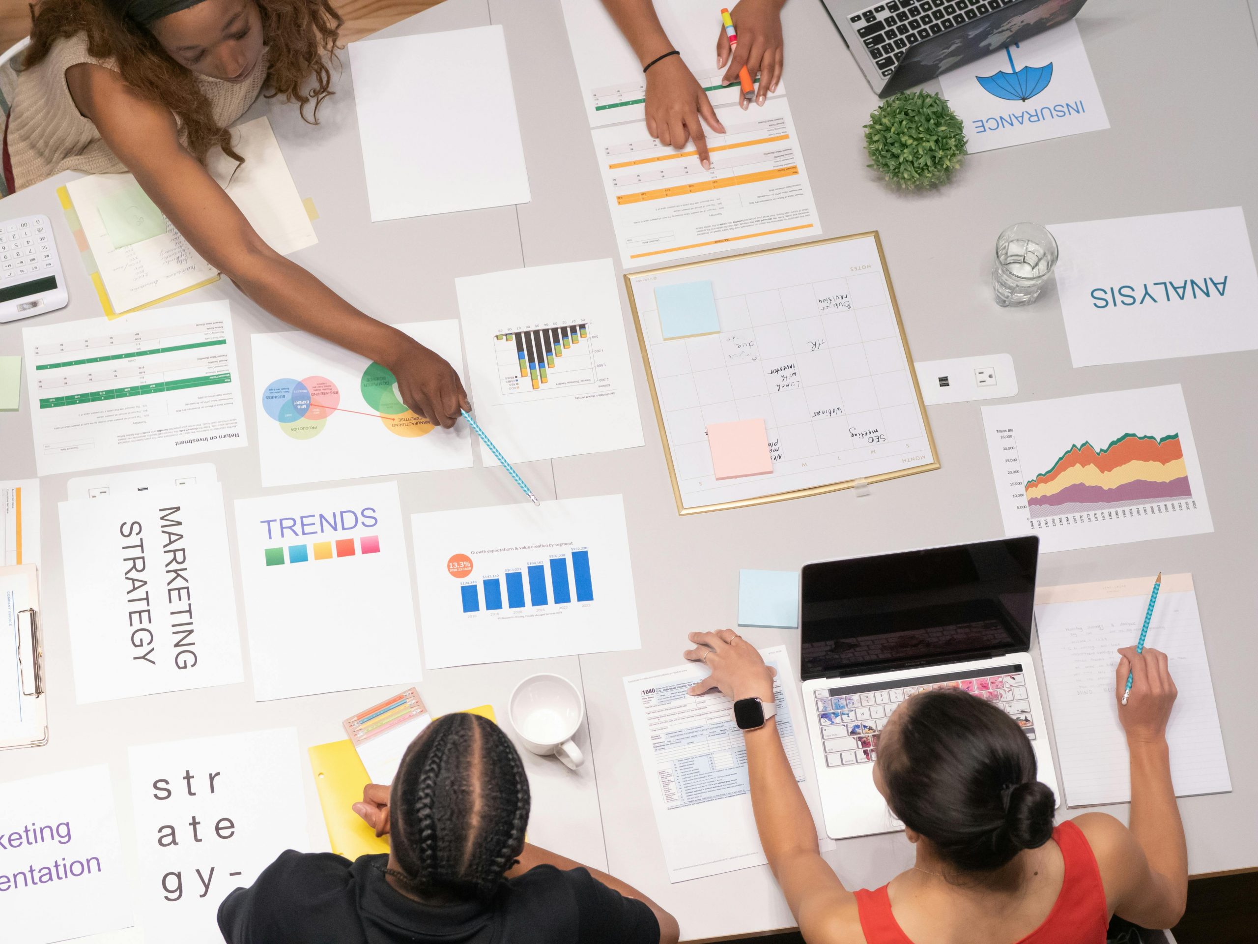 pexels-photo-7688460-7688460 Top view of a team collaborating on marketing strategy and analysis papers.